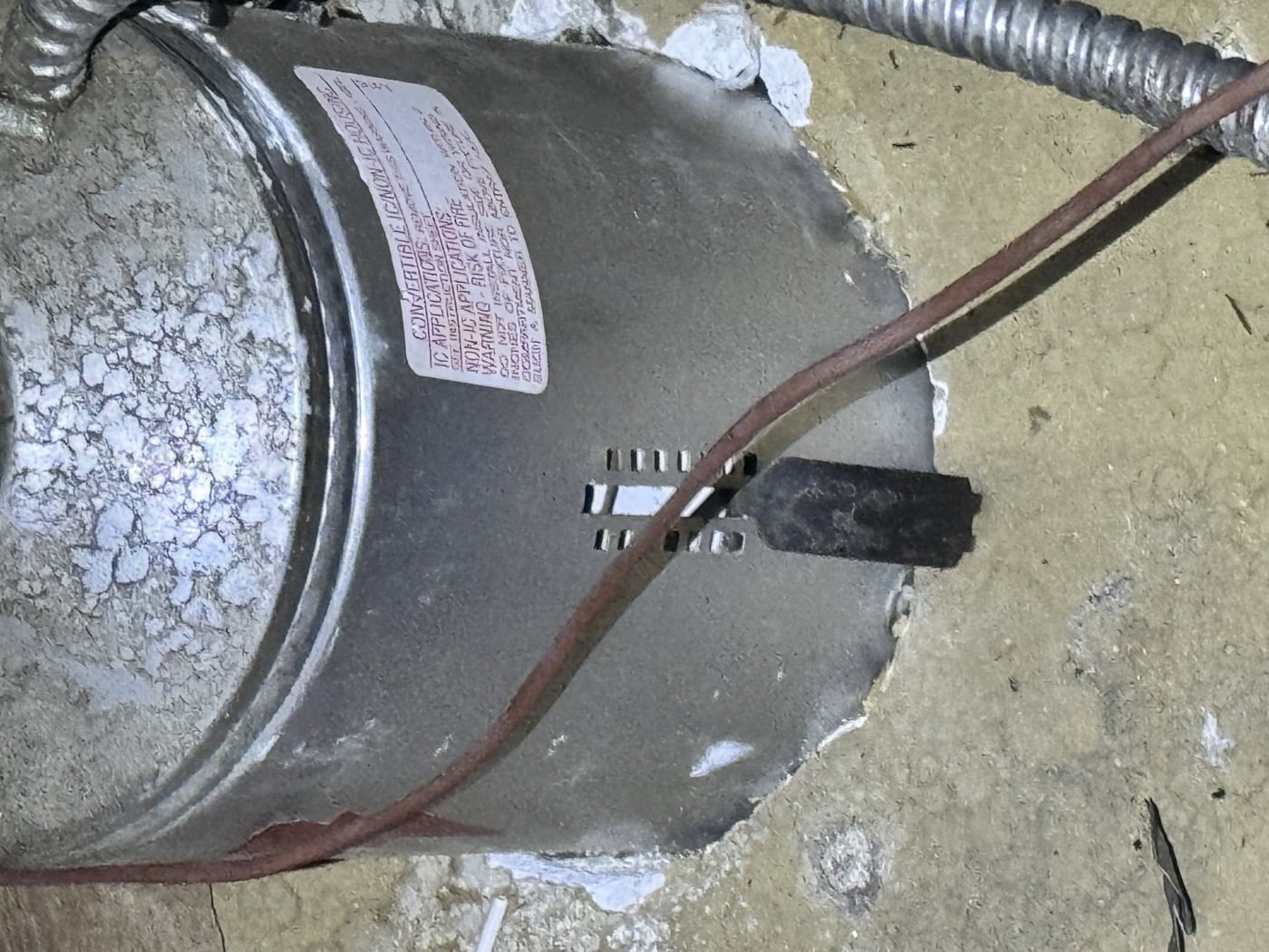 Unsealed flue penetration in a San Marino attic floor before rodent proofing