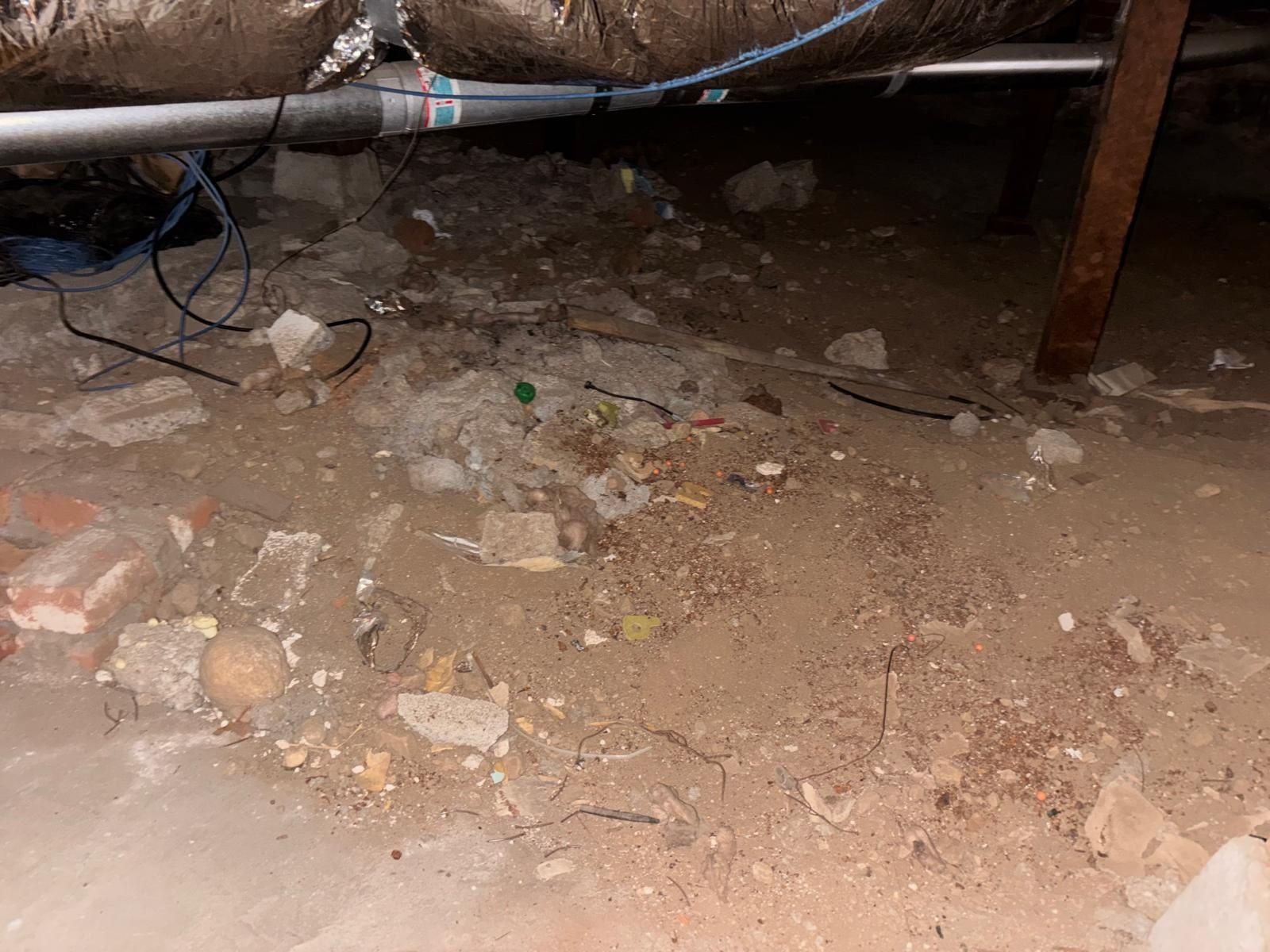 Debris on the soil of a Altadena crawl space before work