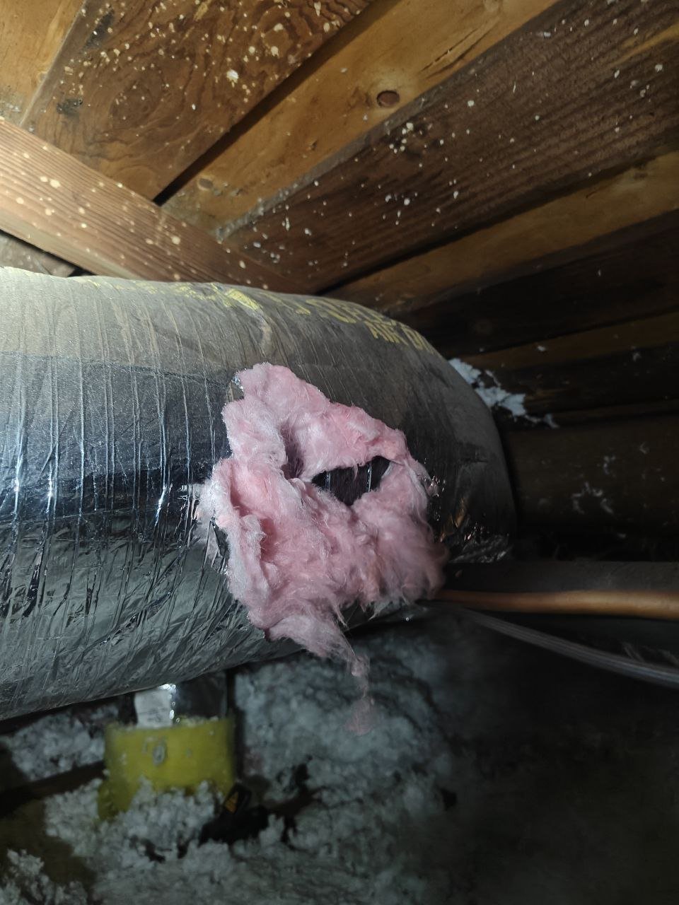 Old air duct with a torn jacket in a Anaheim attic before work