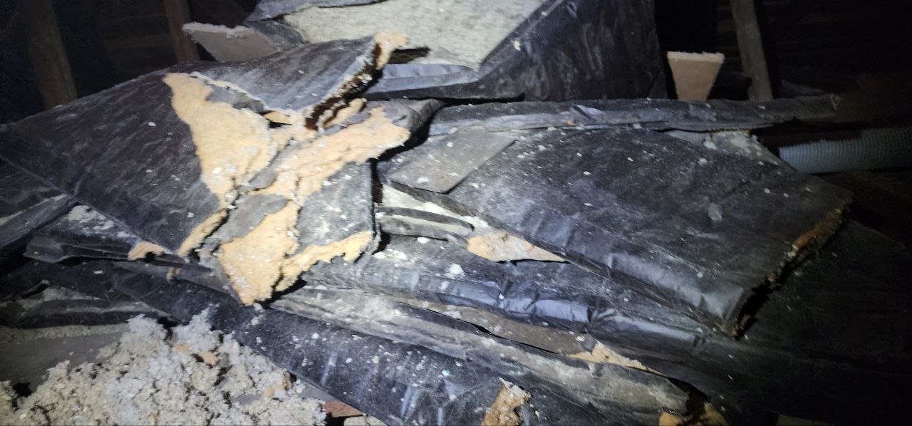 Torn old faced insulation batts in a Berkeley attic before work