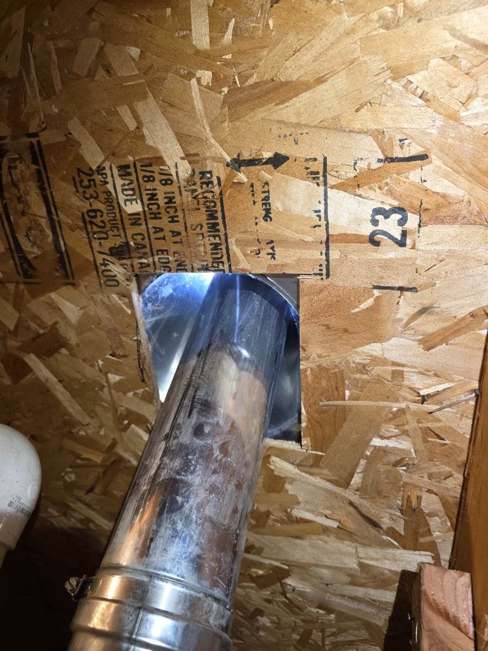 Wire mesh rodent proofing around a flue in a Fremont attic