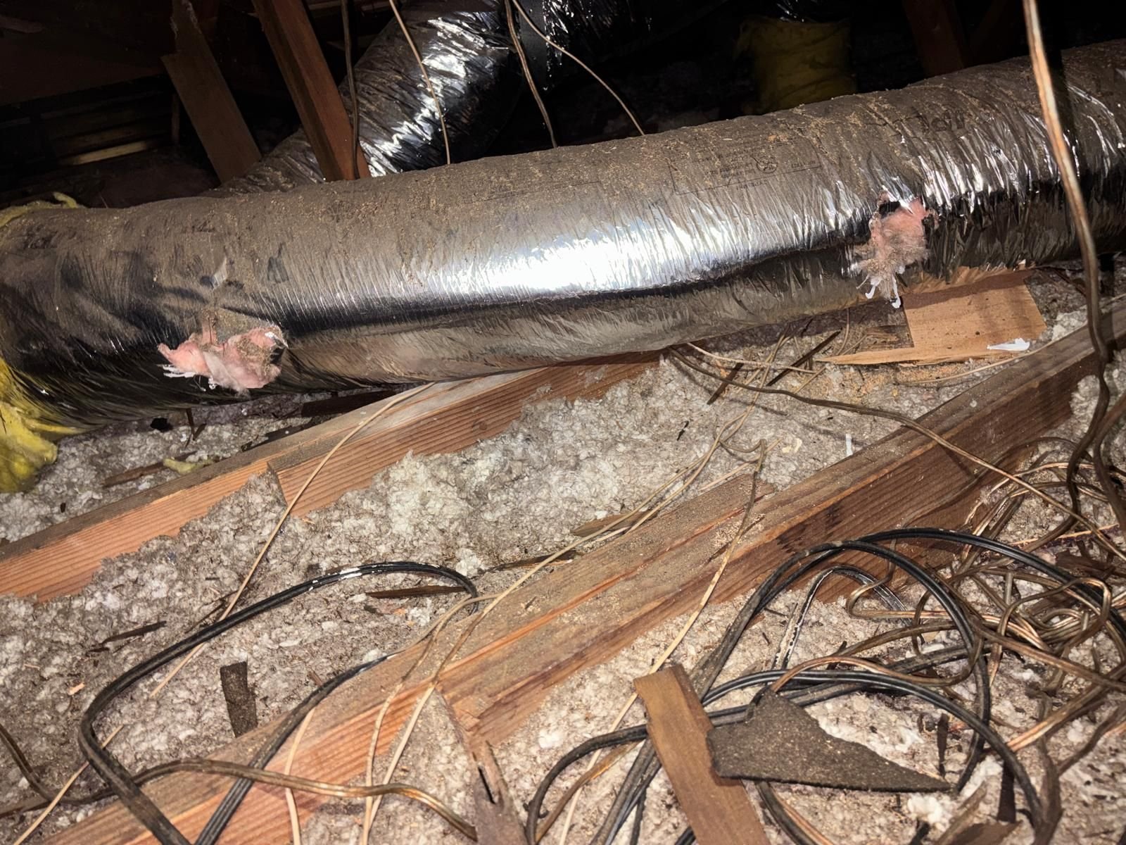 Old duct over old loose-fill and wiring in a Long Beach attic before work