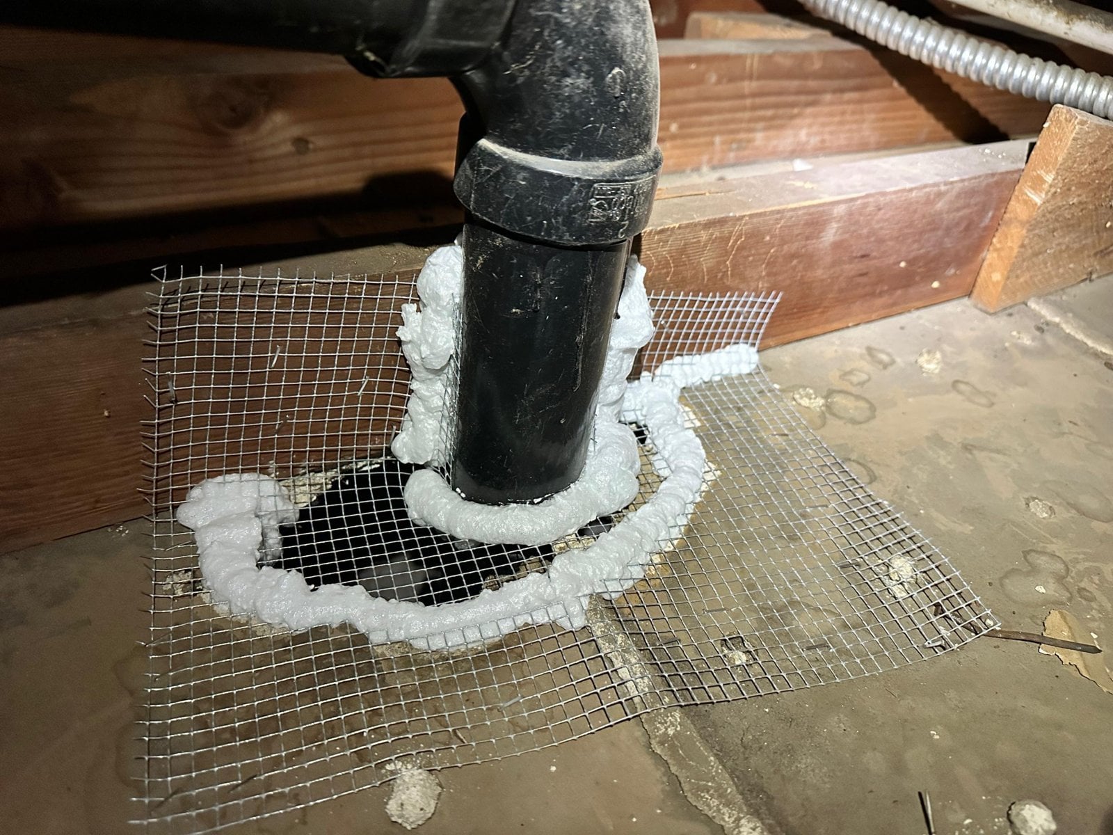 Wire mesh and foam sealing an attic opening in Long Beach