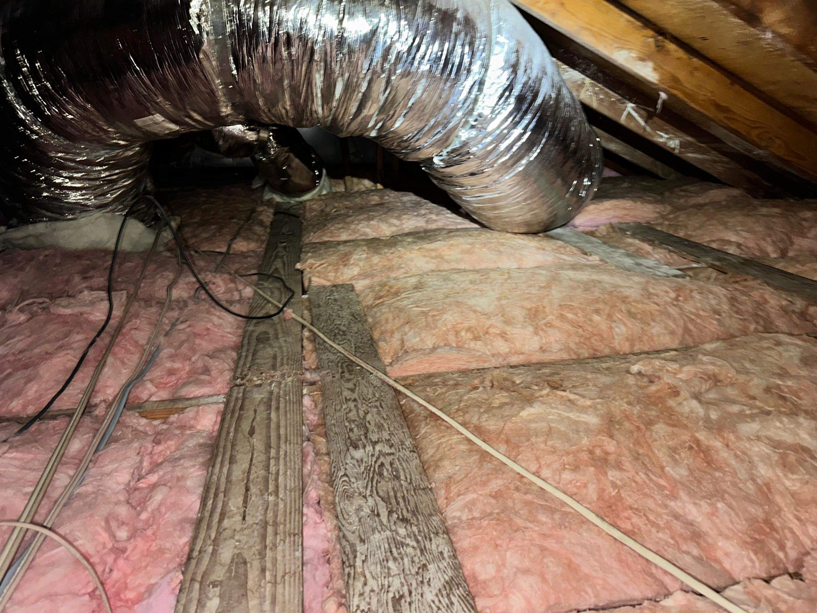 New insulation laid around ducts in a Long Beach attic