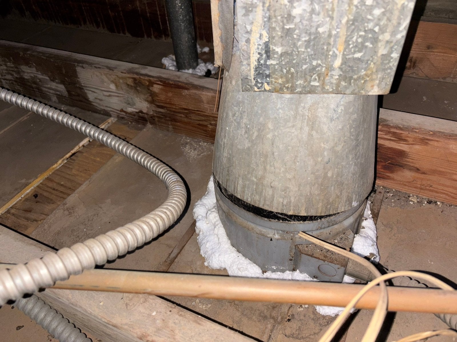 Foam sealing around a metal pipe in a Los Angeles attic