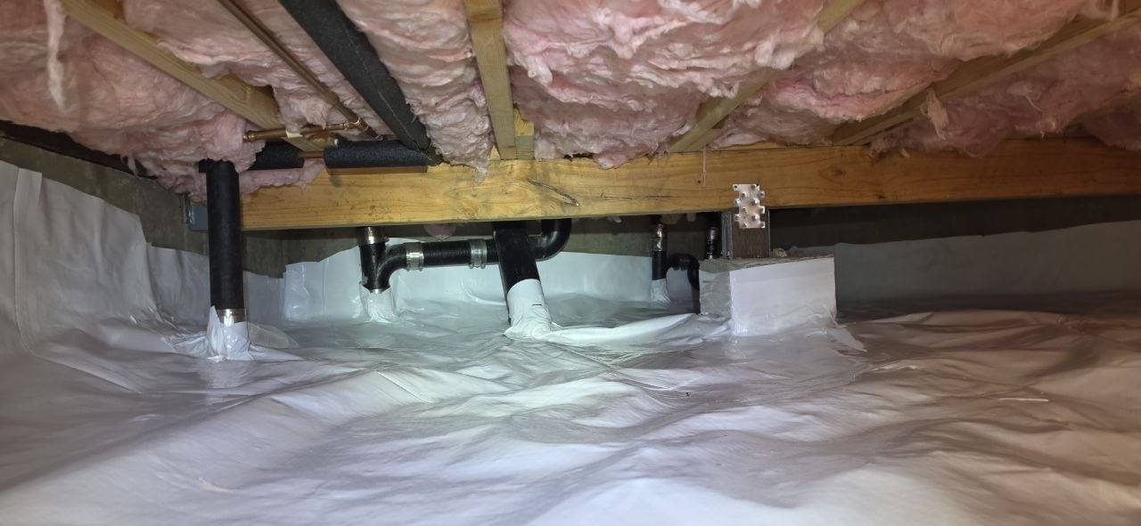 Vapor barrier fitted around plumbing in a Pacifica crawl space