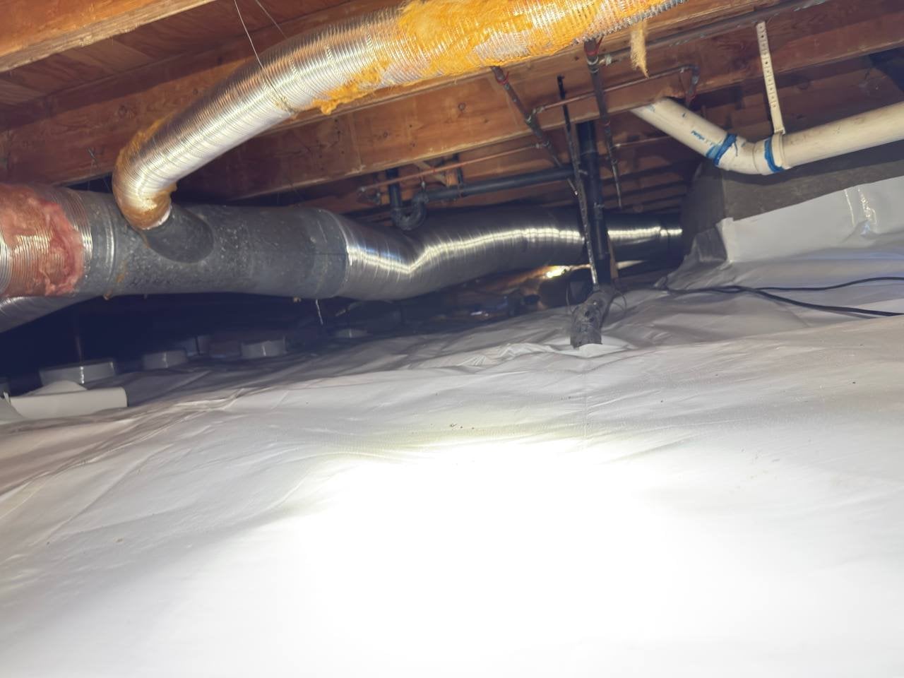 New flexible air ducts over a new vapor barrier in a Petaluma crawl space