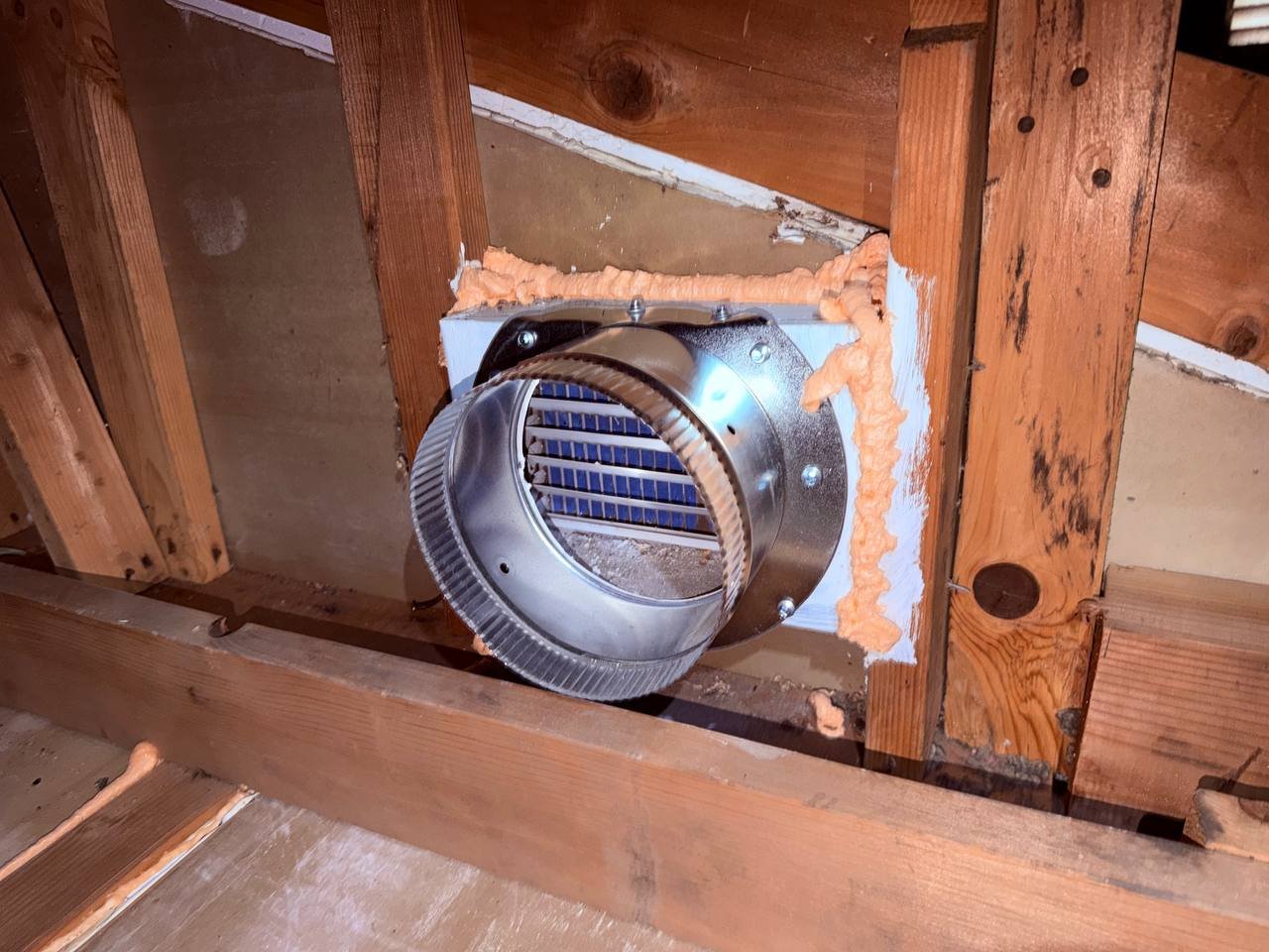 Round vent collar sealed with foam at the attic wall in San Jose