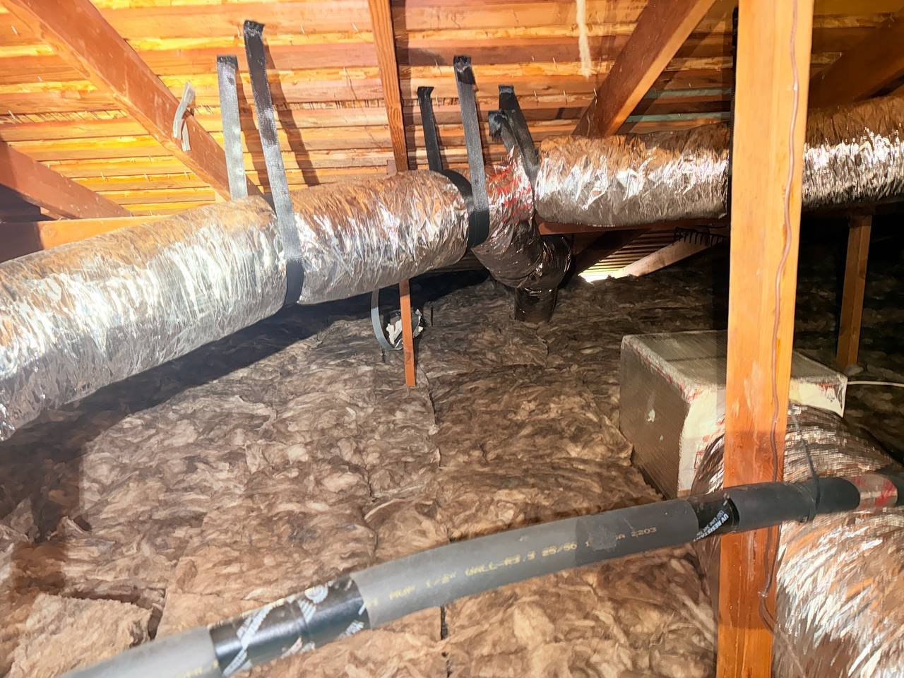 New insulation laid around ducts in a San Jose attic