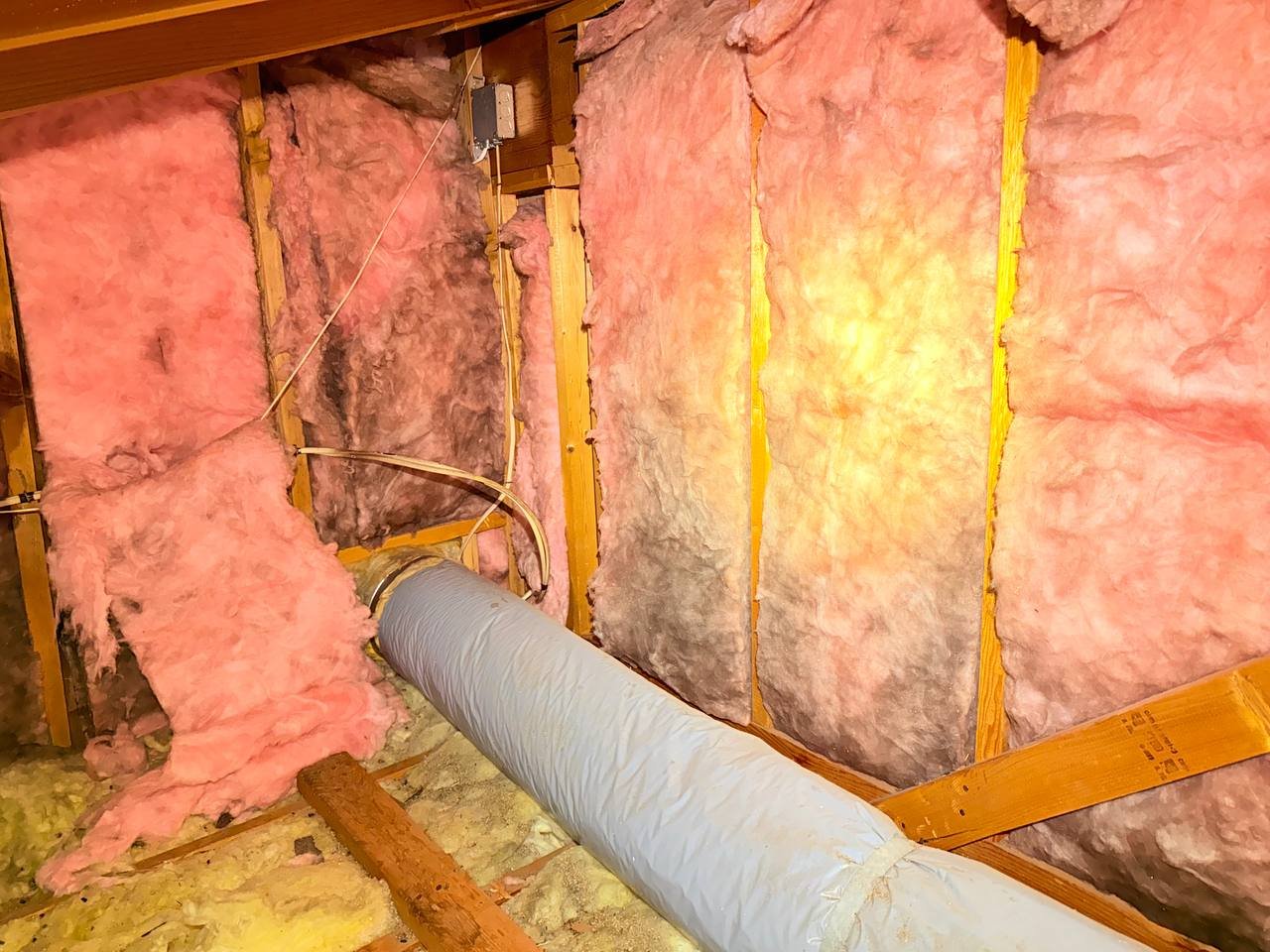 Stained old wall insulation in a San Jose attic before work
