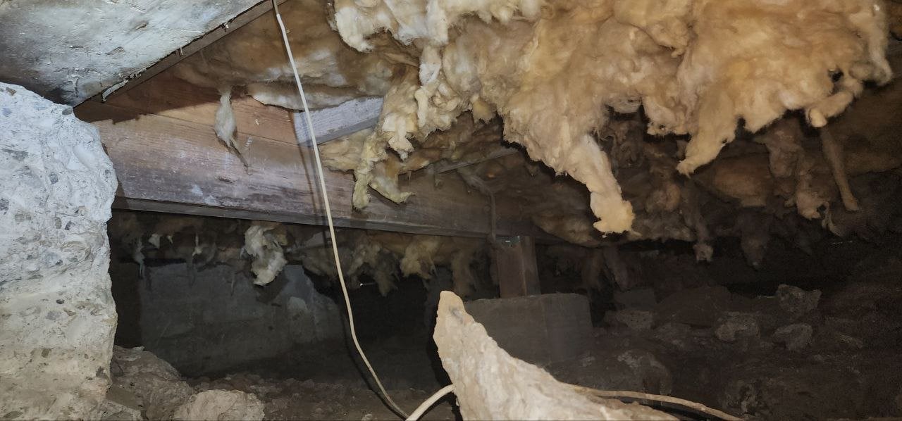 Loose old insulation in the San Jose crawl space before work