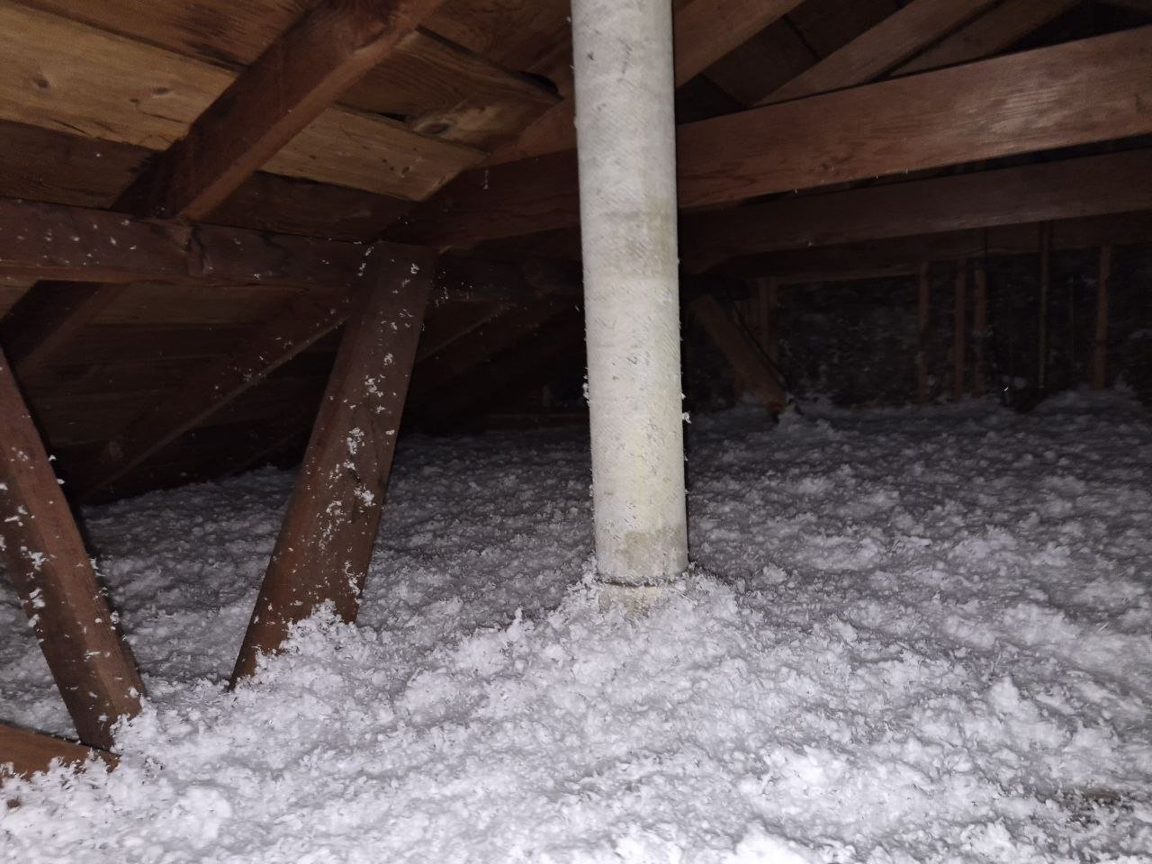 New blown-in insulation around a pipe in a San Leandro attic