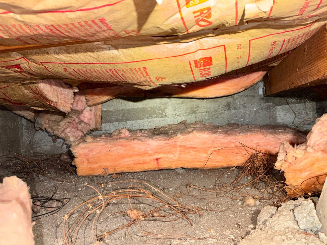 Old batts lying on the soil in a Sunnyvale crawl space before work