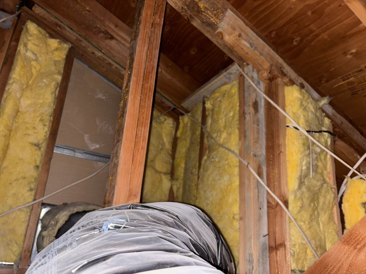 Old insulation batts in attic wall framing in Torrance before work