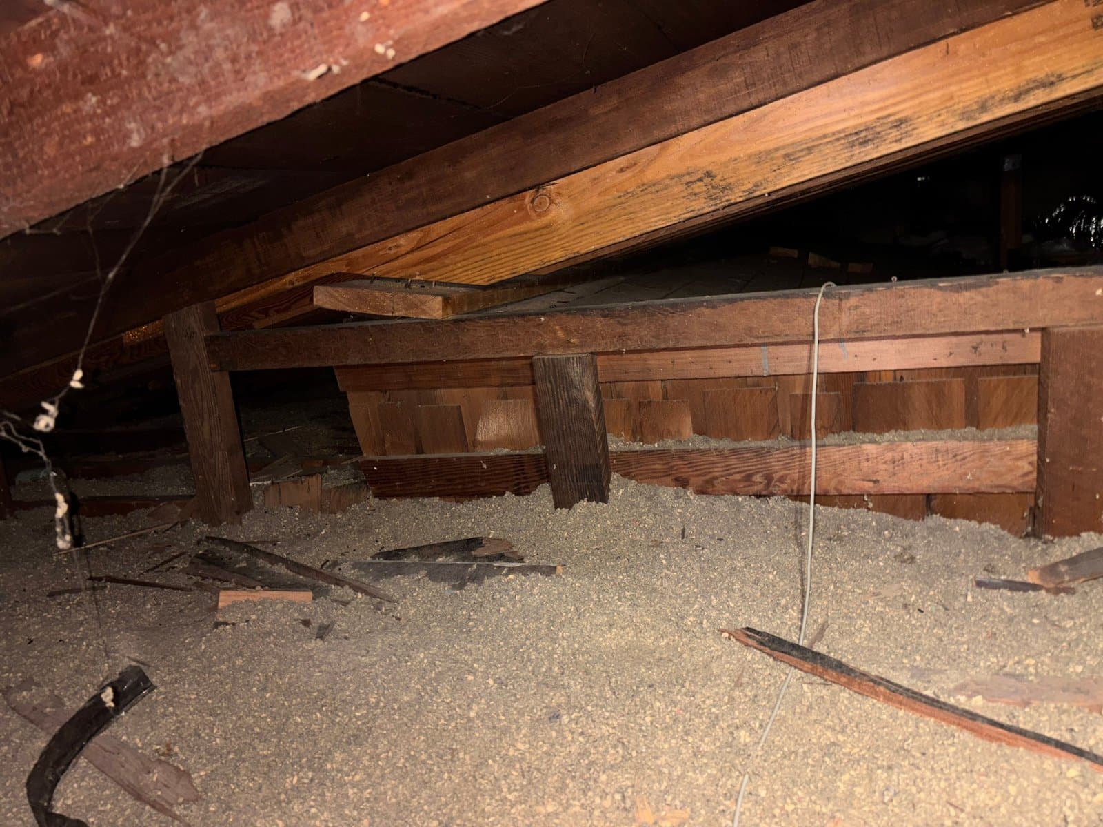 Pasadena attic before work, old loose-fill insulation and debris
