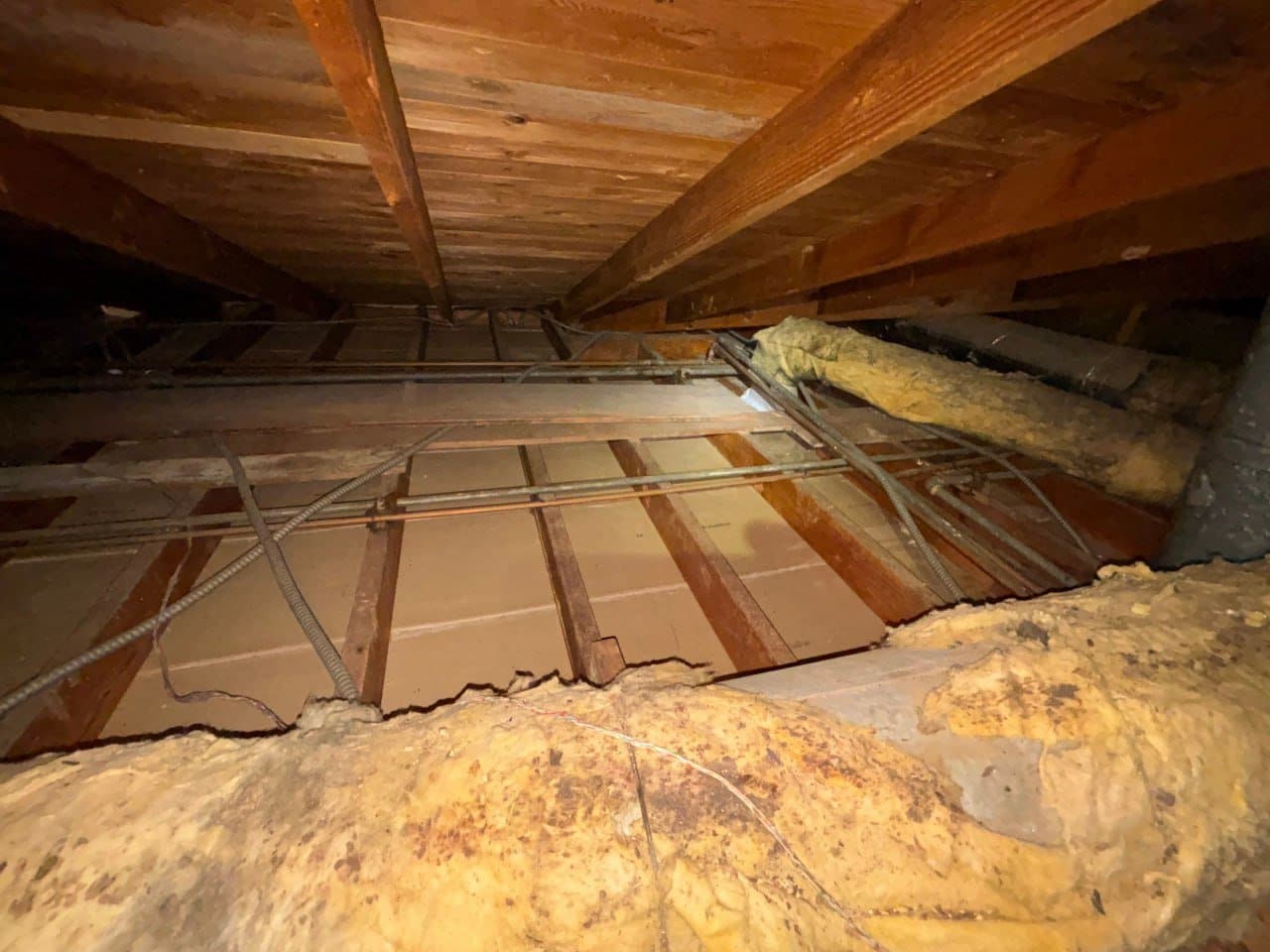 Old fiberglass insulation in a Pasadena attic before work